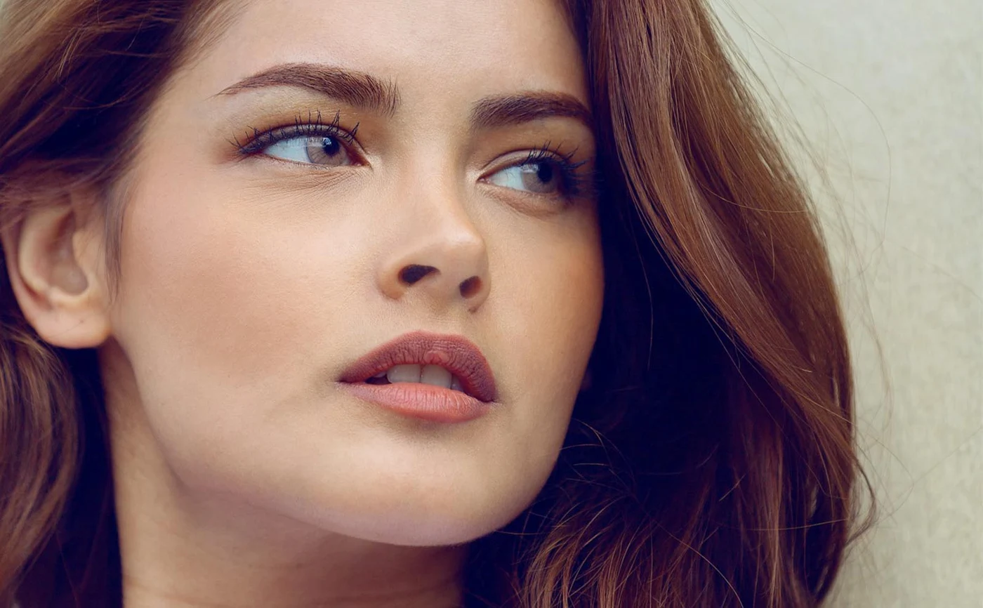 Natural close-up portrait of a woman with long auburn hair.